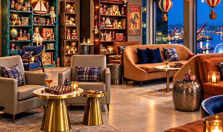 The Toy Room at Fog Room with vintage toy shelves, hot air balloon teddy bears and a waterfront night view